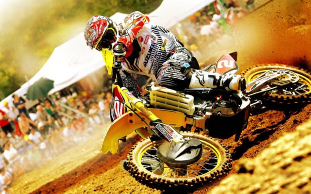 A motocross rider in full gear races on a dirt track during a competition, HD Desktop Wallpaper