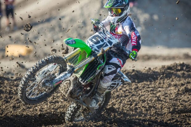 A motocross rider in full gear riding a bike through muddy terrain during a race, HD Desktop Wallpaper