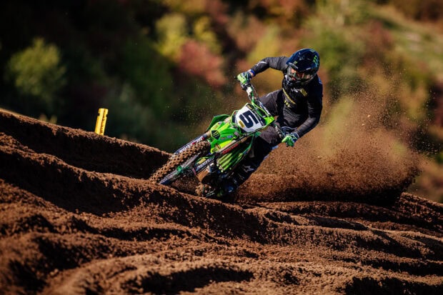 A motocross rider is speeding through a dirt track with dirt flying behind him, HD Desktop Wallpaper