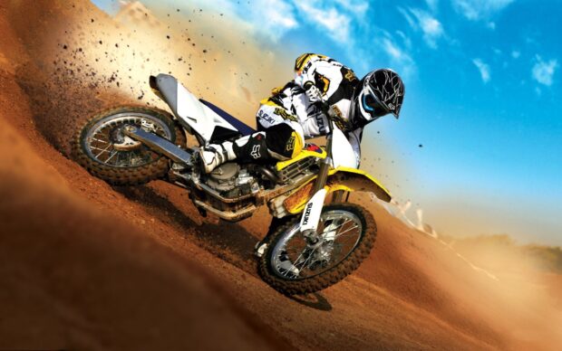 A motocross rider is making a sharp turn on a dirt track during a race, kicking up dust, HD Desktop Wallpaper