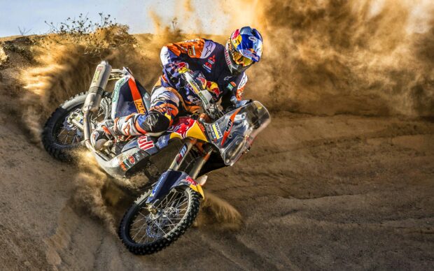 A motocross rider turns sharply while kicking up dirt on a rugged track during a race, 2K Desktop Wallpaper