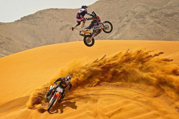 Two motocross riders race through golden sand dunes creating cloud of dust, HD Desktop Wallpaper