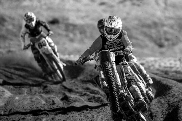 Three motocross riders compete intensely on a rough dirt track during the race, HD Desktop Wallpaper