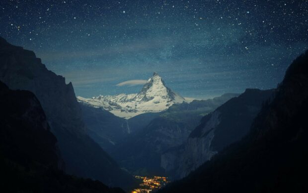 Snow covered mountain peak under starry night sky with Mount Everest in view