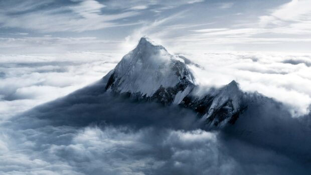 Snow covered Mount Everest peak rising above clouds in high resolution