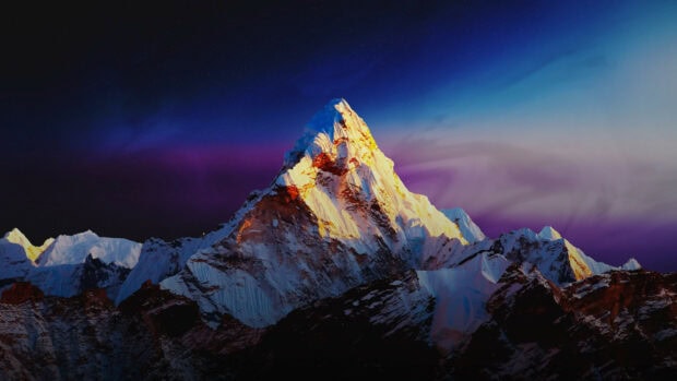 Snow covered Mount Everest under a starry night sky with colorful aurora light