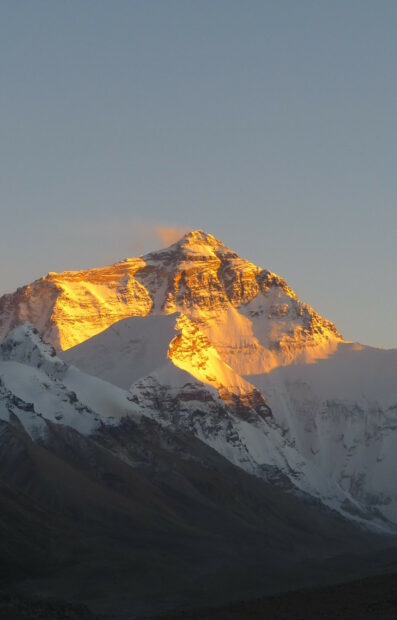 Mount Everest shows golden sunlight on its snowy peak during sunrise