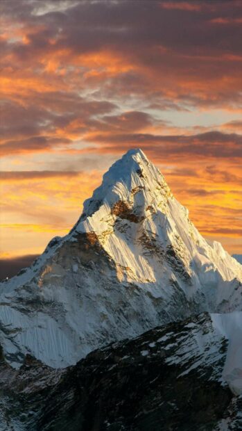 Snow covered mount everest peak under a colorful sunset sky in the mountains