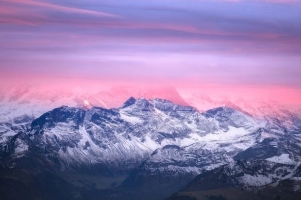 Snow covered Mount Pilatus with a pink sky at sunrise in high definition