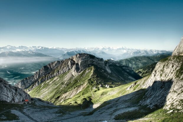 A stunning view of Mount Pilatus with rocky cliffs and green slopes under a clear blue sky