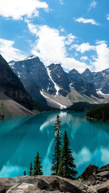 A mountain lake reflects snowy peaks and green trees under a partly cloudy sky, HD Phone Wallpaper