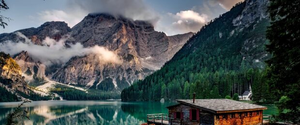 A peaceful scene of a bungalow by the lake surrounded by forest and mountains, 4K Desktop Wallpaper