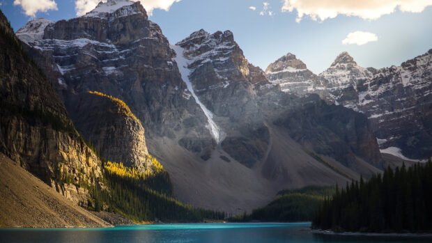 A mountain scenery with a clear turquoise lake and dense forest under a bright sky, 4K Desktop Wallpaper