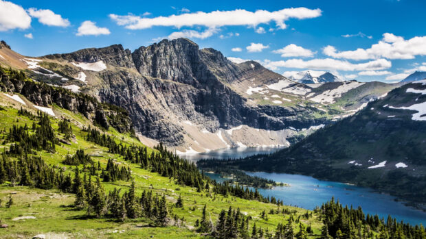 A scenic landscape of Glacier National Park with mountains and a clear blue river, 2K Desktop Wallpaper
