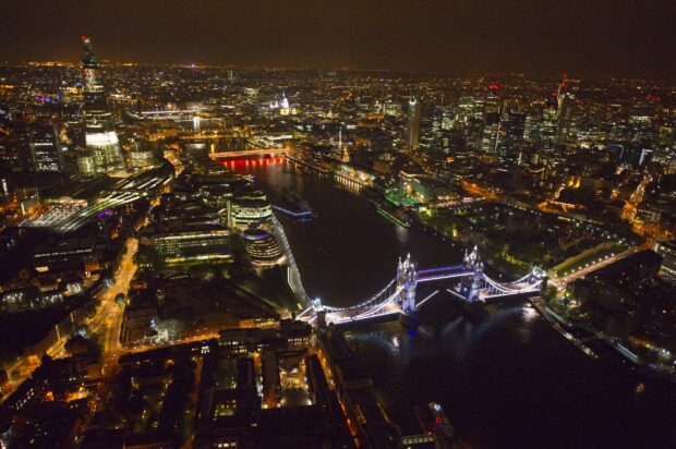 The River Thames captures the glowing cityscape and historic bridges at night, 2K Desktop Wallpaper