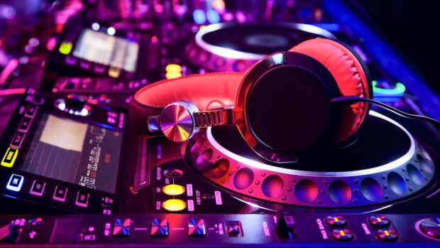 A close up of nightclub DJ headphones resting on the mixer during a vibrant party night, 4K Desktop Wallpaper