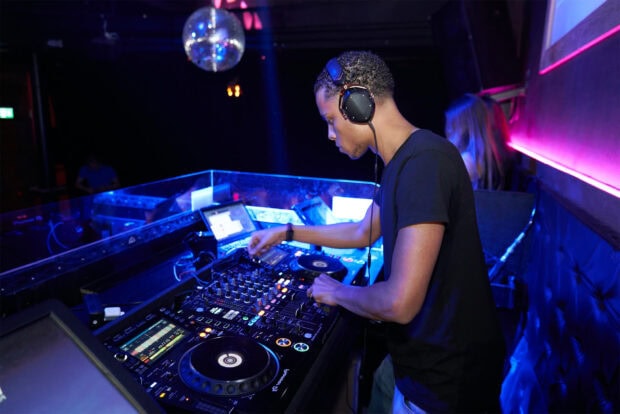 A nightclub DJ is mixing music with professional equipment during a night event, HD Desktop Wallpaper