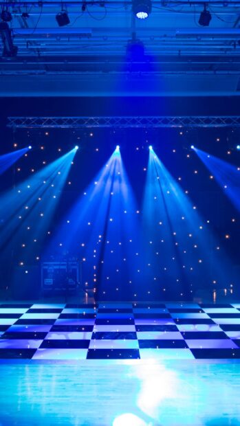A nightclub with blue light beams shining on a checkered dance floor decorated with small stars, 2K Mobile Wallpaper