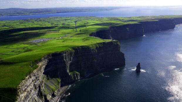 A scenic view of Northern Ireland cliffs and coastline under a clear sky, 2K Desktop Wallpaper