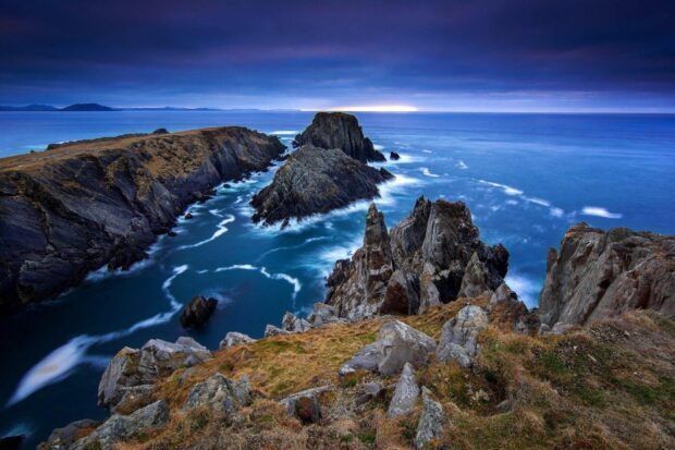 The Northern Ireland Wallpapers show rugged cliffs meeting the ocean under a cloudy sky at dusk, HD Desktop Wallpaper