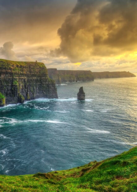 The Northern Ireland Wallpapers show towering cliffs and rough seas under a dramatic sky, 2K Mobile Wallpaper