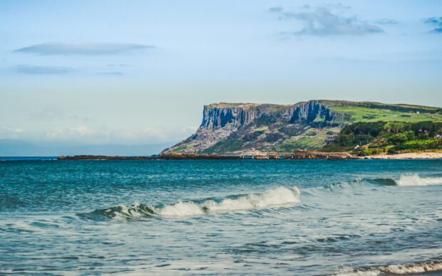 The seashore and cliffs are visible in Northern Ireland with calm waves, 2K Desktop Wallpaper