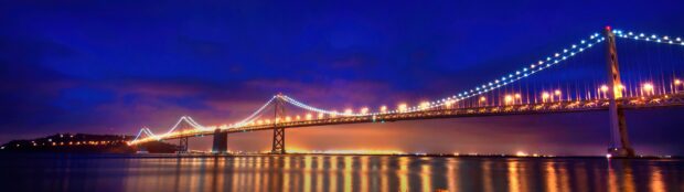 Oakland Wallpaper 4K Desktop glowing lights on the Oakland Bay Bridge reflecting on calm water at night