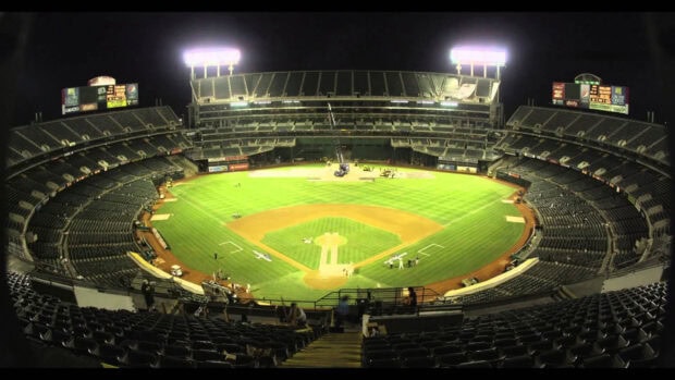 A wide view of an empty baseball stadium under bright lights at night in Oakland