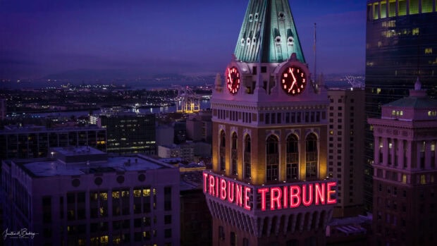 Oakland Wallpaper HD Desktop a nighttime view of the historic Tribune Tower with its illuminated clock and neon sign in Oakland