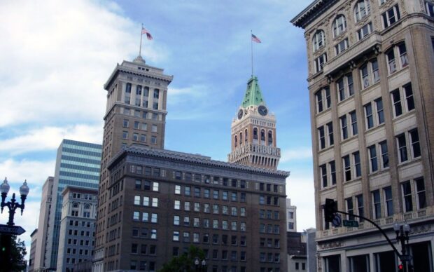 Oakland Wallpaper HD Desktop buildings with American flags and blue sky in Oakland cityscape