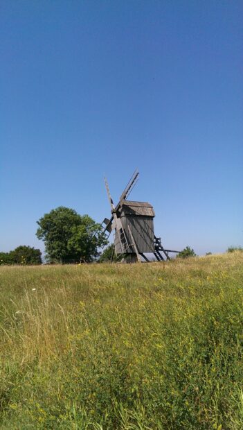 Traditional wooden windmill standing in a green grassy field on Oland Sweden