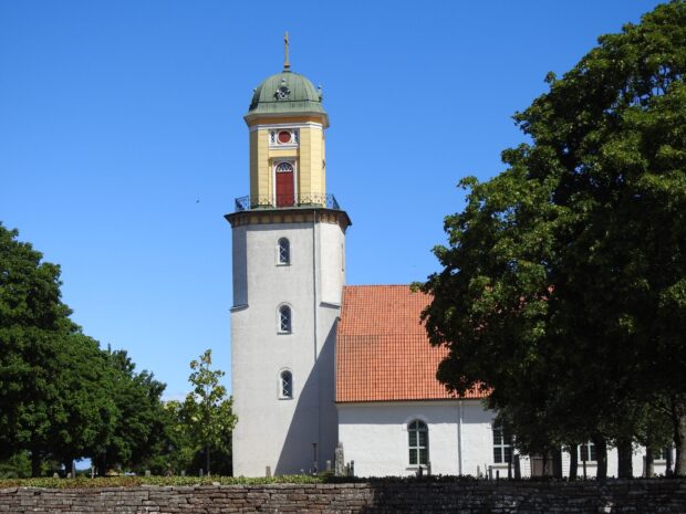 Historic tower in Oland Sweden surrounded by trees and clear blue sky
