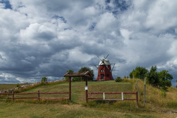 Traditional windmill on a grassy hill in Oland Sweden under cloudy skies
