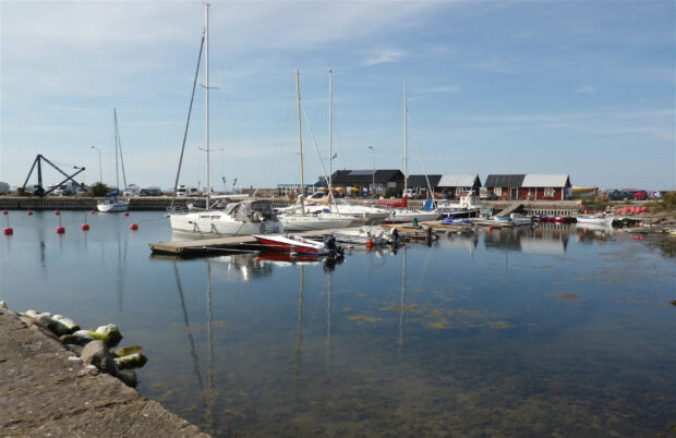 A peaceful harbor scene with boats docked in Oland Sweden reflecting on clear water