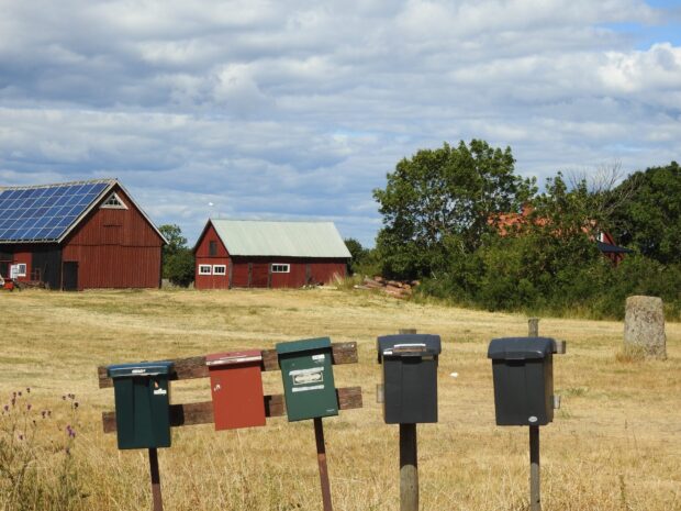 Five rural mailboxes on wooden posts in Oland Sweden countryside