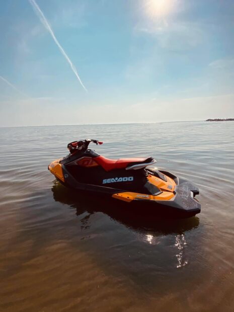 A jet ski is floating peacefully on calm water with a clear sky background, HD Mobile Wallpaper