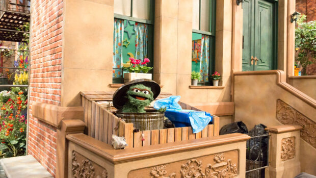 Oscar the Grouch is seen happily popping out of his trash can in a Sesame Street scene, HD Desktop Wallpaper