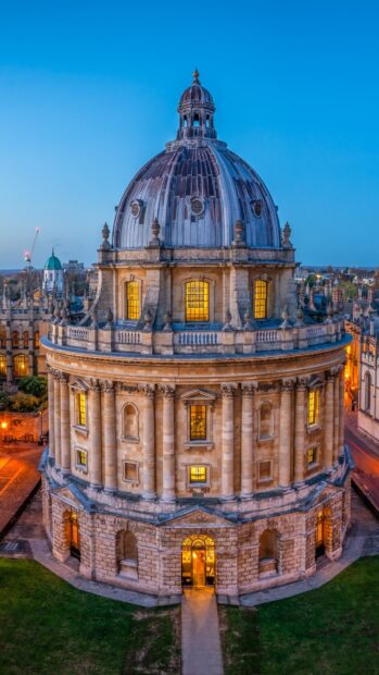 The Radcliffe Camera at Oxford University is lit warmly during dusk in this beautiful city view, HD Phone Wallpaper