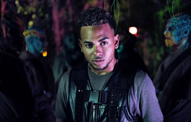 A man with curly hair and a tactical vest stands in a dim environment for Ozuna Wallpapers, HD Desktop Wallpaper