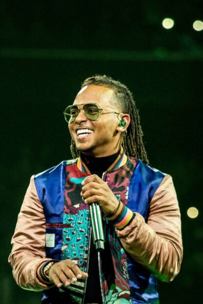 Ozuna is smiling and holding a microphone during a live show, HD Mobile Wallpaper
