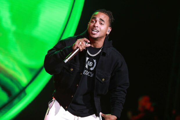 Ozuna is singing and holding a microphone during a concert performance, 2K Desktop Wallpaper