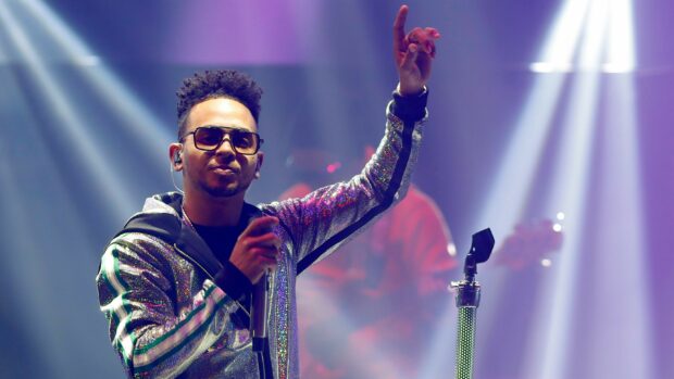 Ozuna performs energetically in a bright concert setting with colorful lights, 2K Desktop Wallpaper