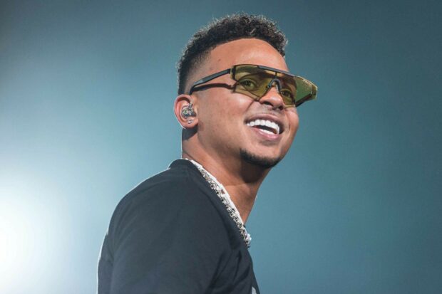 Ozuna is smiling brightly with sunglasses during a live performance, HD Desktop Wallpaper