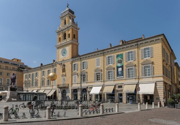 Historical building with clock tower in Parma Italy city center