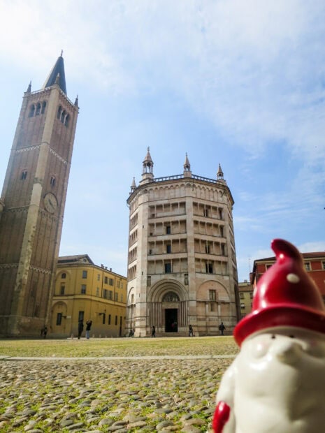Historic architecture in Parma Italy with a gnome figurine in the foreground