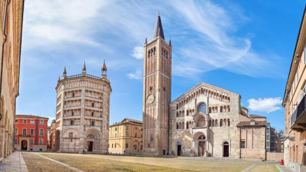 The historic architecture of Parma Italy with the cathedral and baptistery under a blue sky
