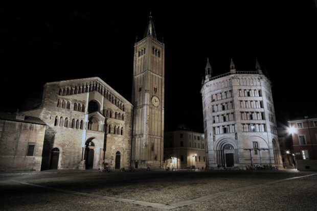Historic architecture in Parma Italy with cathedral and baptistery at night