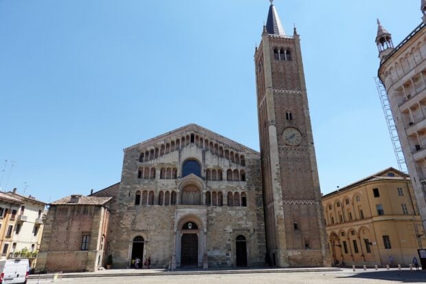 Historic Parma Italy architecture with cathedral and clock tower under clear blue sky