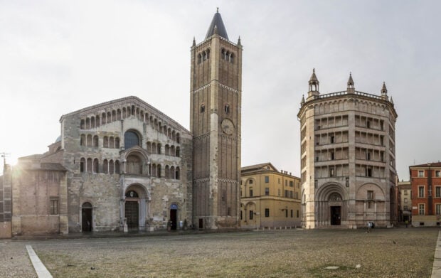 Historic Parma Italy buildings with cathedral and baptistery in city square at sunrise