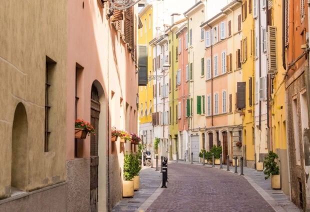 Narrow street in Parma Italy with colorful old buildings and flower pots